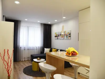 a kitchen with a table and chairs and a living room at Borovets Gardens Luxury apartment E11 in Borovets