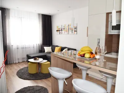 a kitchen and living room with a table and a couch at Borovets Gardens Luxury apartment E11 in Borovets