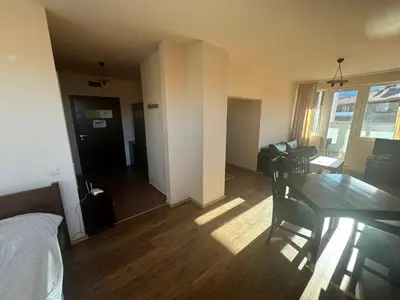a room with a dining table and a living room at Bansko Royal Towers - Studio 153 in Bansko