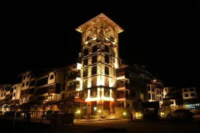 a large building with a clock tower at night at Bansko Royal Towers - Studio 1237 in Bansko