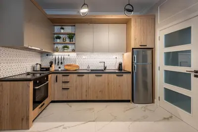 a kitchen with wooden cabinets and a stainless steel refrigerator at Top Center 2 Aptartments - Gurko Str in Sofia