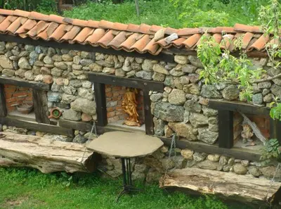 a stone building with a fire place in front of it at Старата къща / село Тъжа in Tŭzha