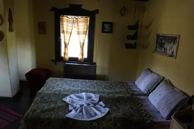 a bedroom with a bed with a dress on it at Старата къща / село Тъжа in Tŭzha