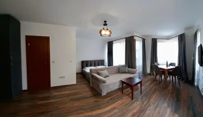 a living room with a couch and a table at Pirin Golf Hotel Private Studios - Sani, Bansko in Razlog