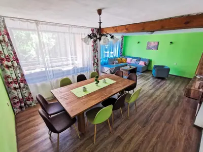 a dining room with a wooden table and chairs at Вила Край реката in Botevgrad