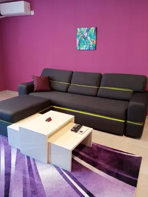 a living room with a black couch and a table at Ultraviolet relax apart in Sofia