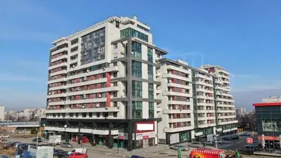 a large apartment building in a parking lot with cars at Ultraviolet relax apart in Sofia