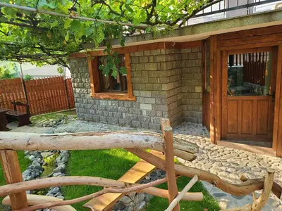a brick house with a wooden door and a window at Вила 111 in Sapareva Banya