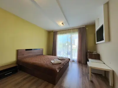 a bedroom with a bed and a large window at Дамяновата къща in Sapareva Banya