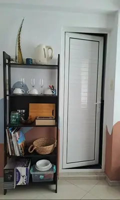 a door in a room with a shelf with plates and glasses at Студио Цвят/ Studio Colour in Blagoevgrad