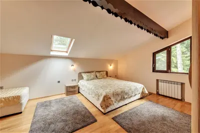 a bedroom with a bed and two rugs at Комплекс Орлово гнездо in Beli Iskar