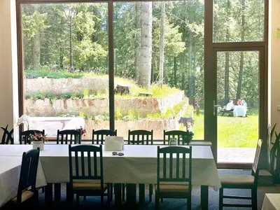 a dining room with a table and chairs and a large window at Комплекс Орлово гнездо in Beli Iskar
