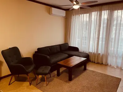a living room with a couch and a table and chairs at Private Spa Luxury apartments in Bansko