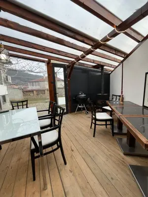 a room with tables and chairs on a wooden floor at Къща Христини in Kalofer