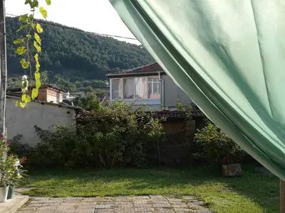 a green tent in front of a house at Къща Христини in Kalofer