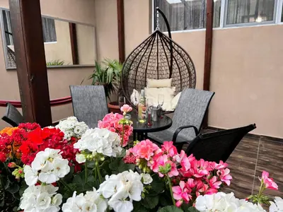 a table and chairs with flowers on a patio at Къща за гости Шарон in Petrich