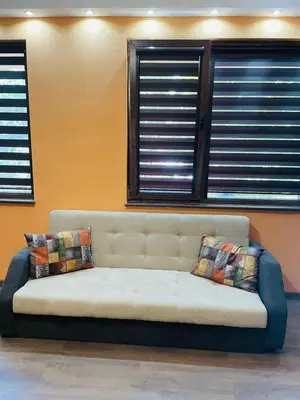 a couch sitting in a room with windows at Къща за гости Станеви in Ribarica