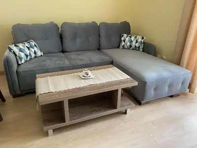 a couch and a coffee table in a living room at Апартамент в MountainLake in Smolyan