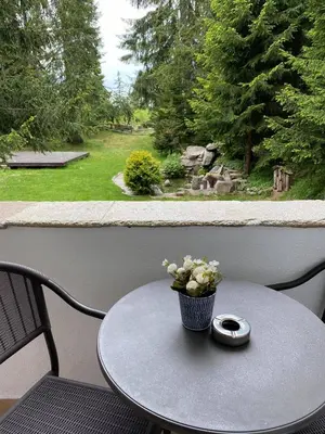 a small table with a vase of flowers on a balcony at Апартамент в MountainLake in Smolyan