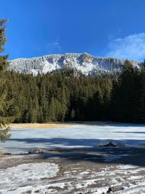 a snow covered mountain in the distance with a lake at Апартамент в MountainLake in Smolyan