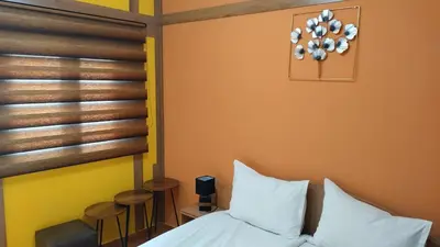 a bedroom with a bed and a table and chairs at Къща за гости Вишнева градина in Brestnik