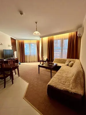a large living room with a bed and a table at Bardarova Apartments Downtown Bansko in Bansko