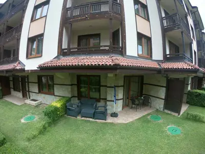 an apartment building with a lawn in front of it at Bardarova Apartments Downtown Bansko in Bansko