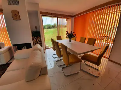 a living room with a couch and a table and chairs at Mountain Villa near Bansko in Razlog