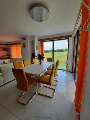 a dining room with a white table and yellow chairs at Mountain Villa near Bansko in Razlog
