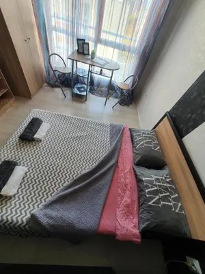 a bed in a room with a table and a window at Nights apartment in Sofia
