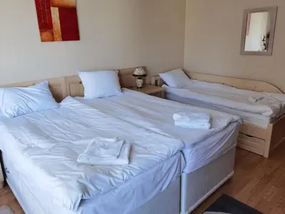 two beds in a room with white sheets and towels at Студио за трима, басейн, Aspen Golf Resort, Банско, Разлог in Razlog