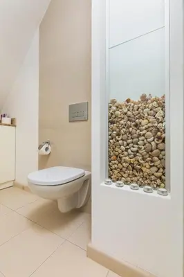 a bathroom with a toilet and a pile of rocks at 1BD Flat with a lovely terrace in the centre of Plovdiv by Flat Mаnager in Plovdiv