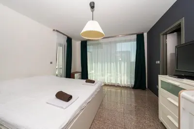 a bedroom with a large bed and a television at Vertigo Modern 2-Bedroom Apartment with Parking & Vitosha View in Sofia