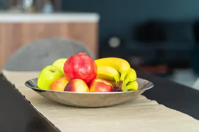 a bowl of apples and bananas on a table at Vertigo Modern 2-Bedroom Apartment with Parking & Vitosha View in Sofia