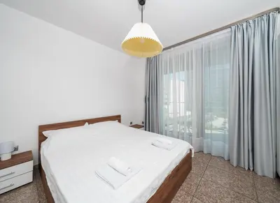a bedroom with a bed and a large window at Vertigo Modern 2-Bedroom Apartment with Parking & Vitosha View in Sofia