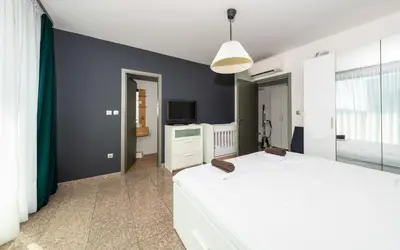a bedroom with a white bed and a tv at Vertigo Modern 2-Bedroom Apartment with Parking & Vitosha View in Sofia