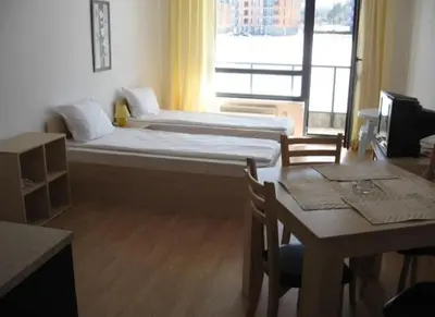 a small room with a bed and a table and a window at Aspen Heights 4 bed studio in Bansko