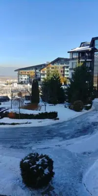 a snow covered street with a building in the background at Aspen Heights 4 bed studio in Bansko