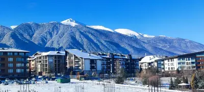 a city with snow covered mountains in the background at Aspen Heights 4 bed studio in Bansko