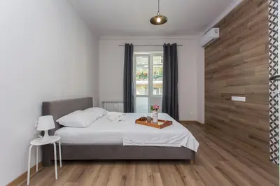 a bedroom with a bed with a wooden wall at Sunny and Modern 1BDR Apartment in the Center in Sofia