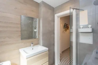 a bathroom with a white sink and a shower at Sunny and Modern 1BDR Apartment in the Center in Sofia