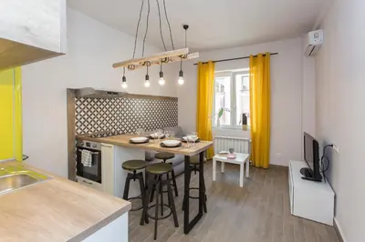 a kitchen with a table and some yellow curtains at Sunny and Modern 1BDR Apartment in the Center in Sofia