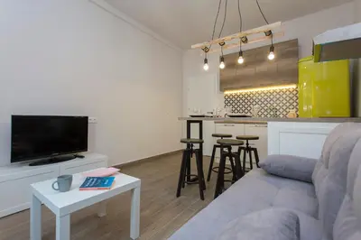 a living room with a couch and a kitchen at Sunny and Modern 1BDR Apartment in the Center in Sofia