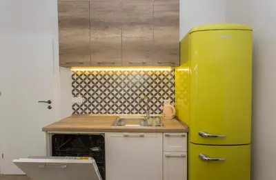 a yellow refrigerator in a kitchen with a sink at Sunny and Modern 1BDR Apartment in the Center in Sofia