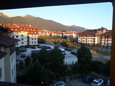 a view of a parking lot with buildings and mountains at Старият Хан-Б24 in Bansko