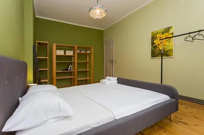 a large bed in a room with green walls at Colorful 2BDR Apartment in the City Center in Sofia