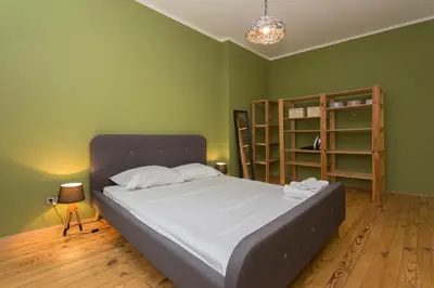 a green bedroom with a bed and a book shelf at Colorful 2BDR Apartment in the City Center in Sofia