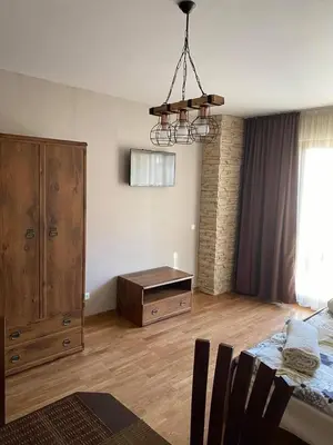 a bedroom with a bed and a dresser and a chandelier at Bansko SPA Studio at Predela1 in Bansko