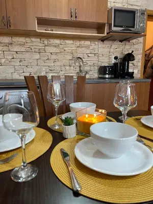 a table with plates and wine glasses on it at Bansko SPA Studio at Predela1 in Bansko