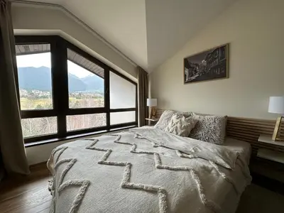 a bedroom with a large bed and a large window at Luxury Apartment Pirin Chalet in Terra Complex in Bansko
